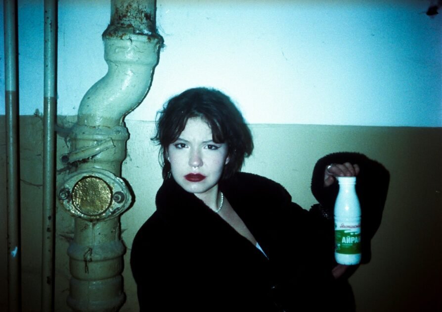 Woman holding a milk bottle near pipe